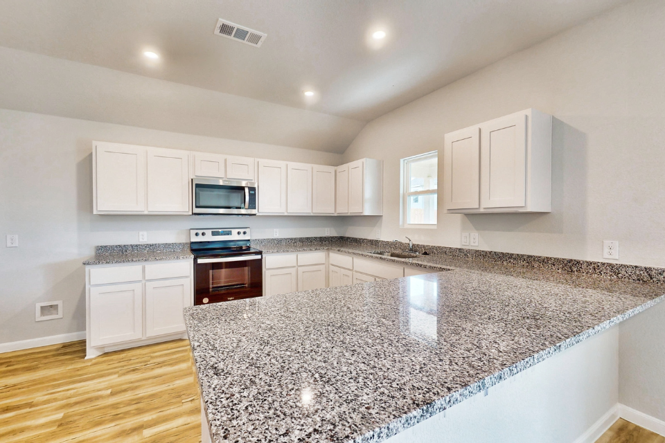 A kitchen with marble counters.