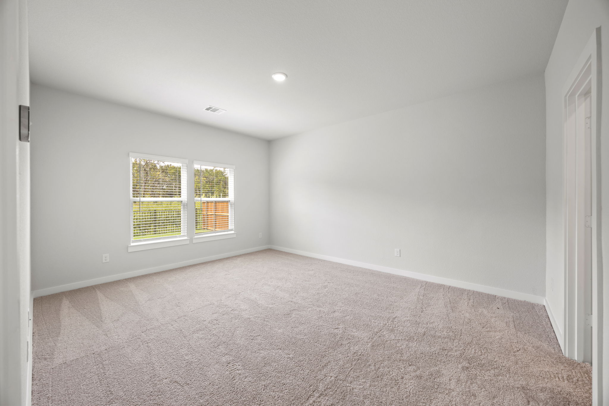 A room with a window and carpet.