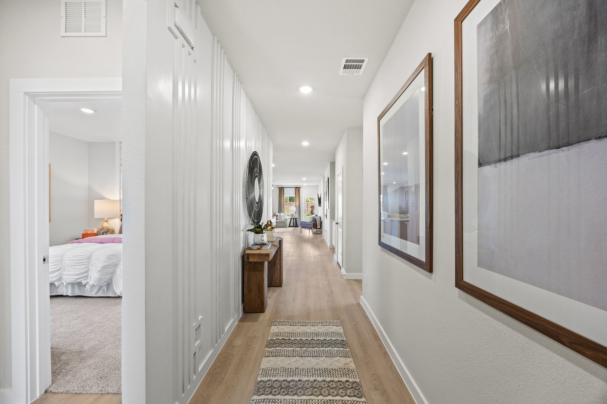 A hallway with a bed and a mirror.