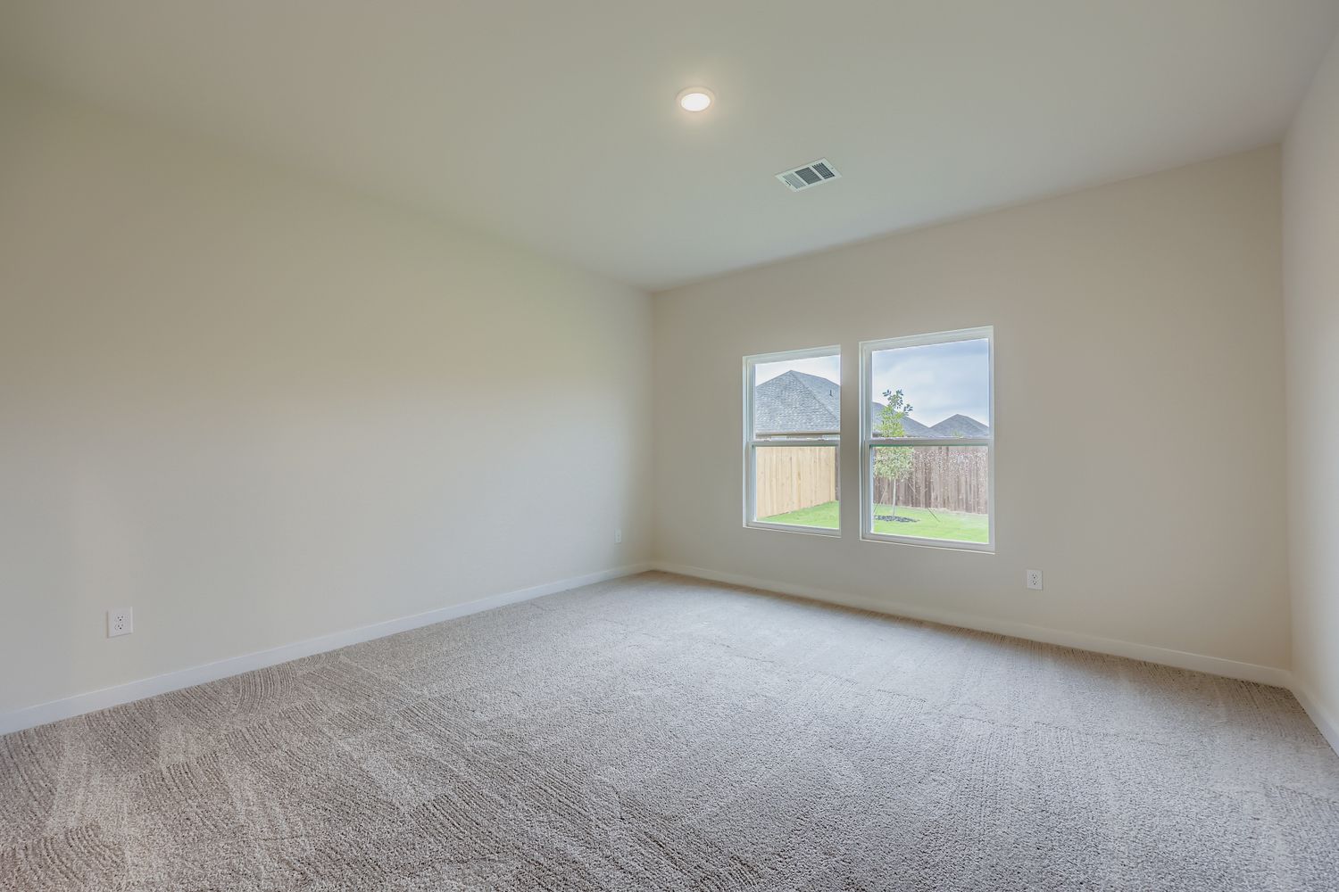 A room with a carpet and a window.