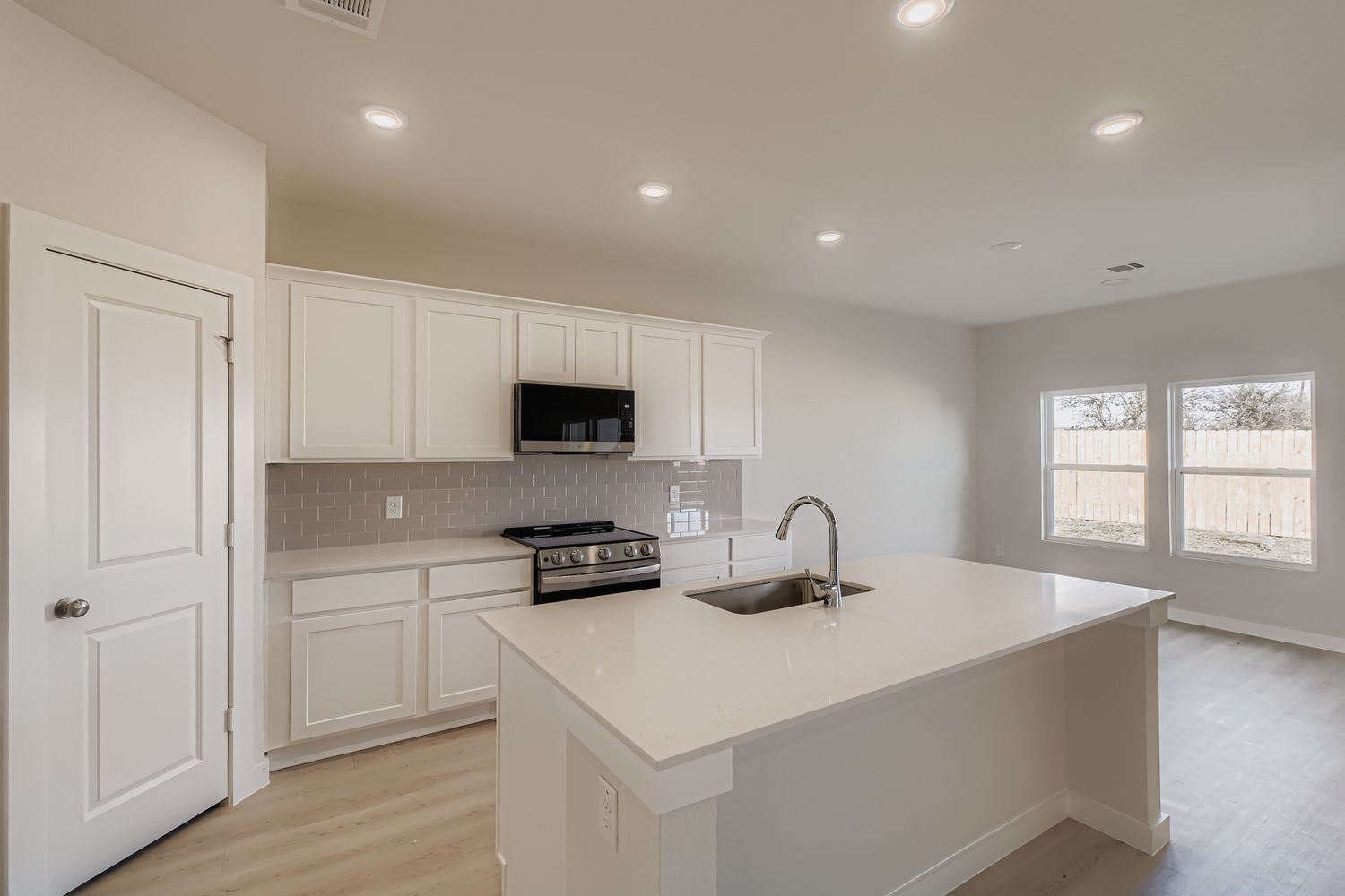 A kitchen with white cabinets.