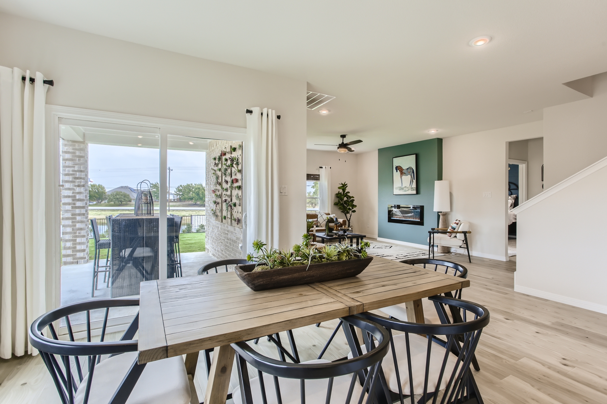 A dining room table with chairs and a large window.