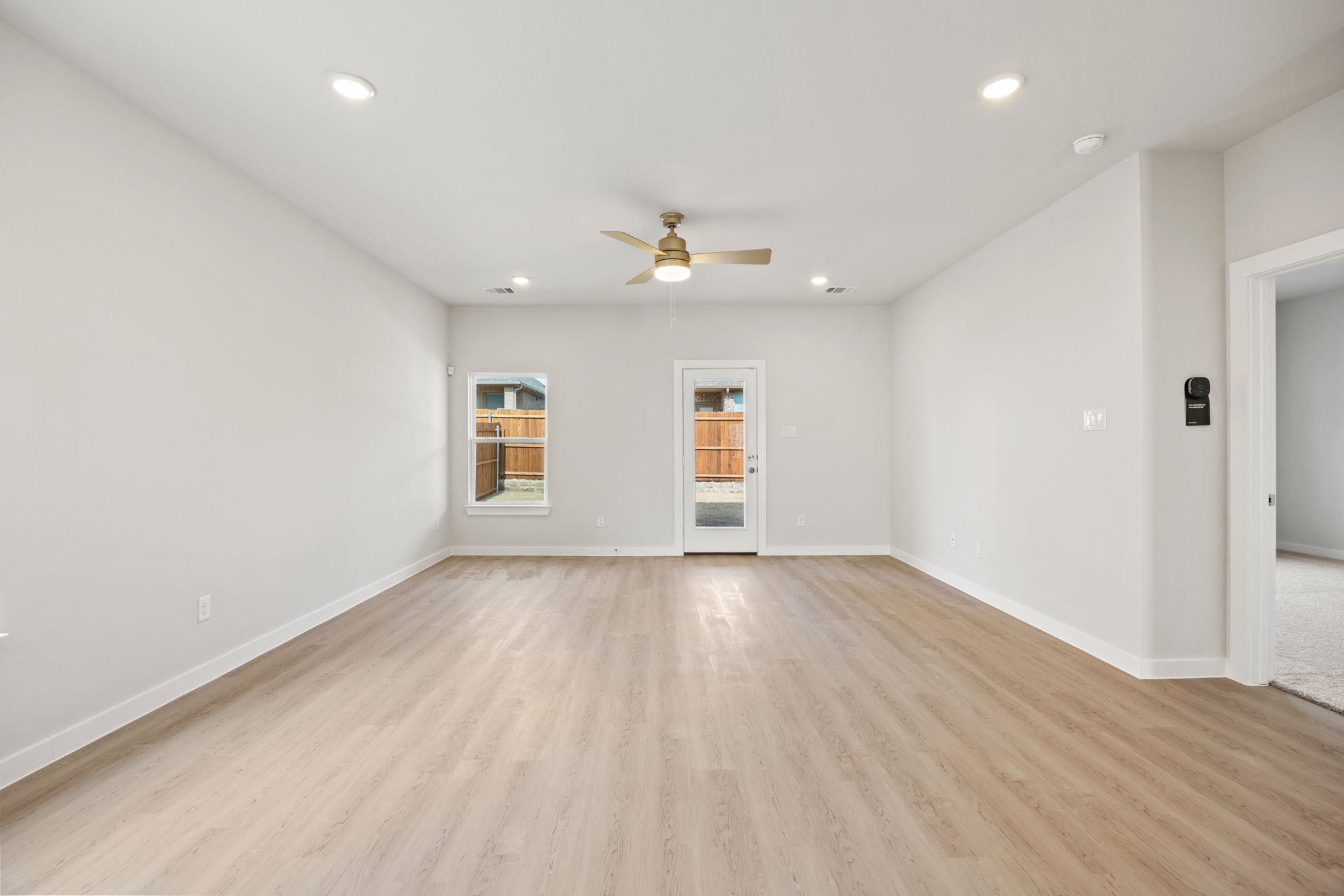A room with a wood floor and a ceiling fan.