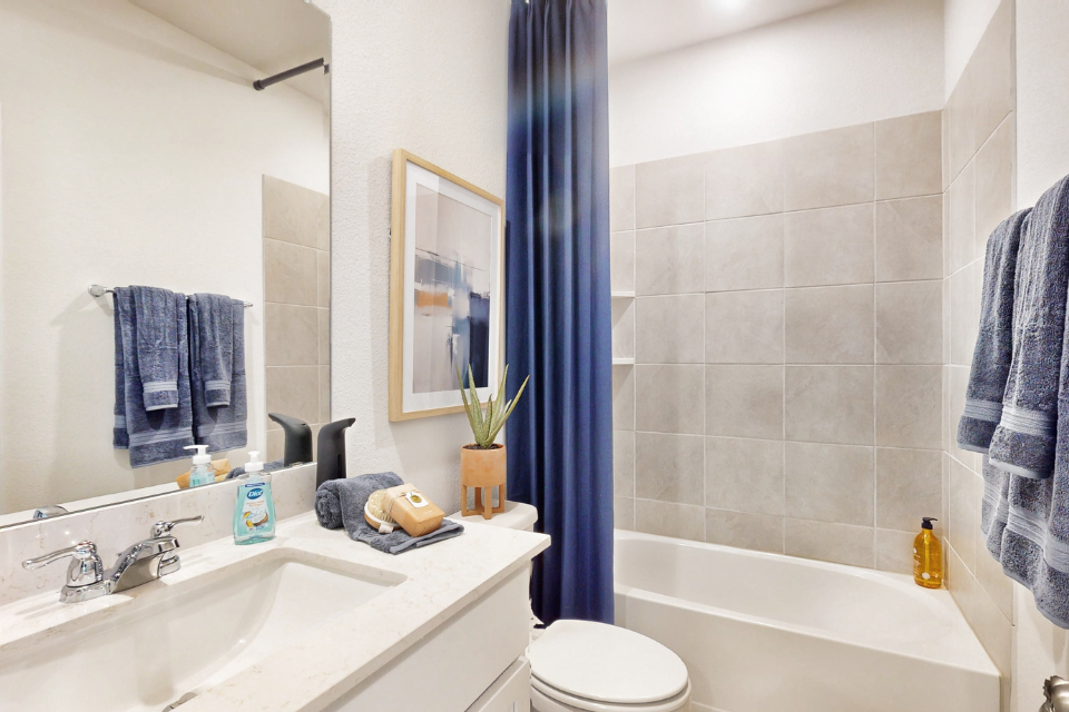 A bathroom with a blue shower curtain.