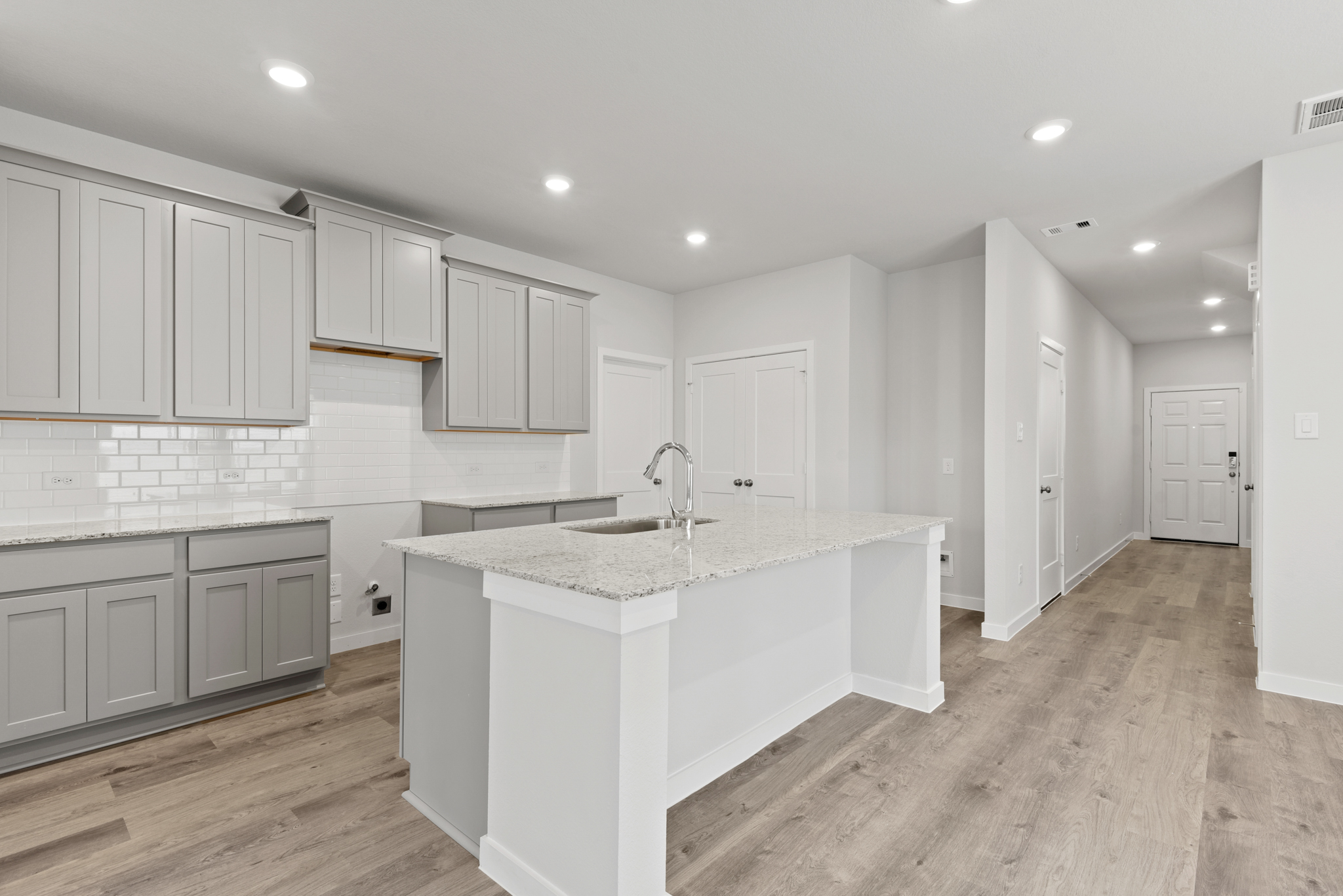 A kitchen with white cabinets.