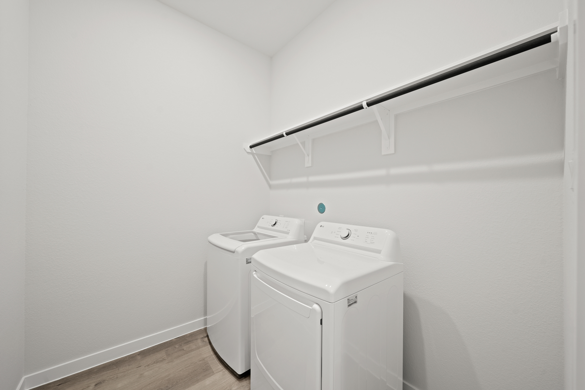 A white wall with a white shelf and a white wall with a vent.