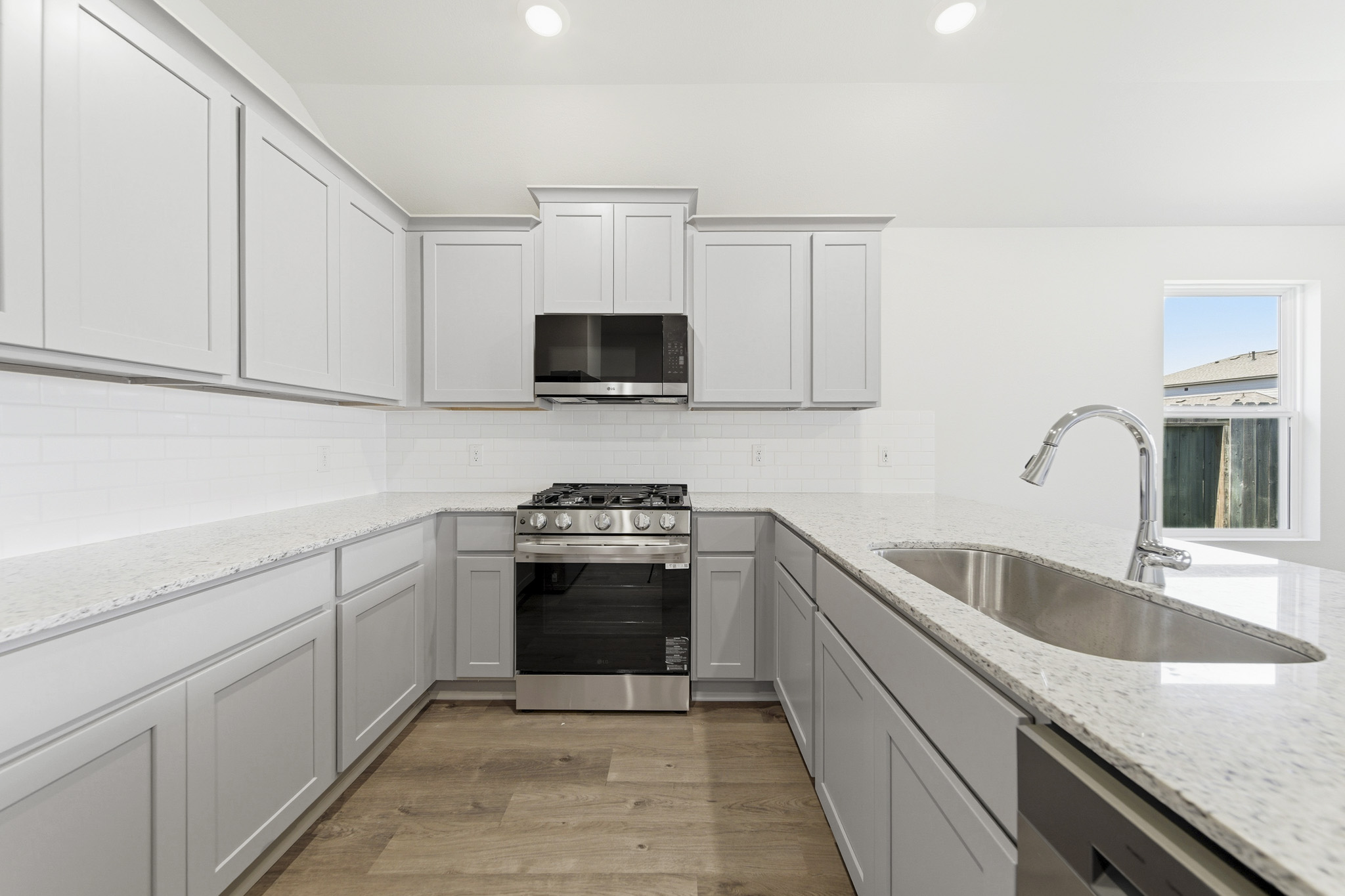 A kitchen with white cabinets.