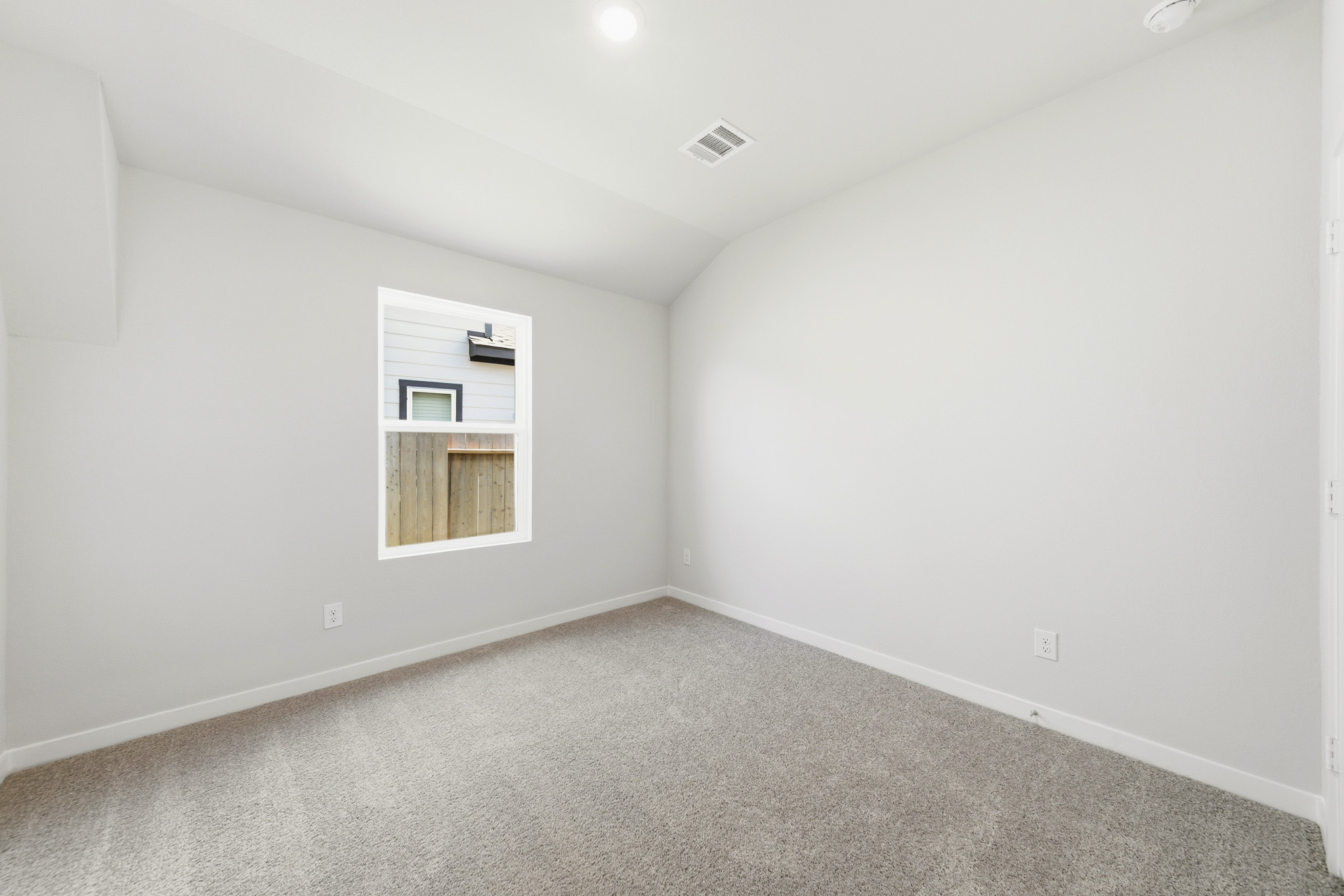 A room with a carpet and a window.