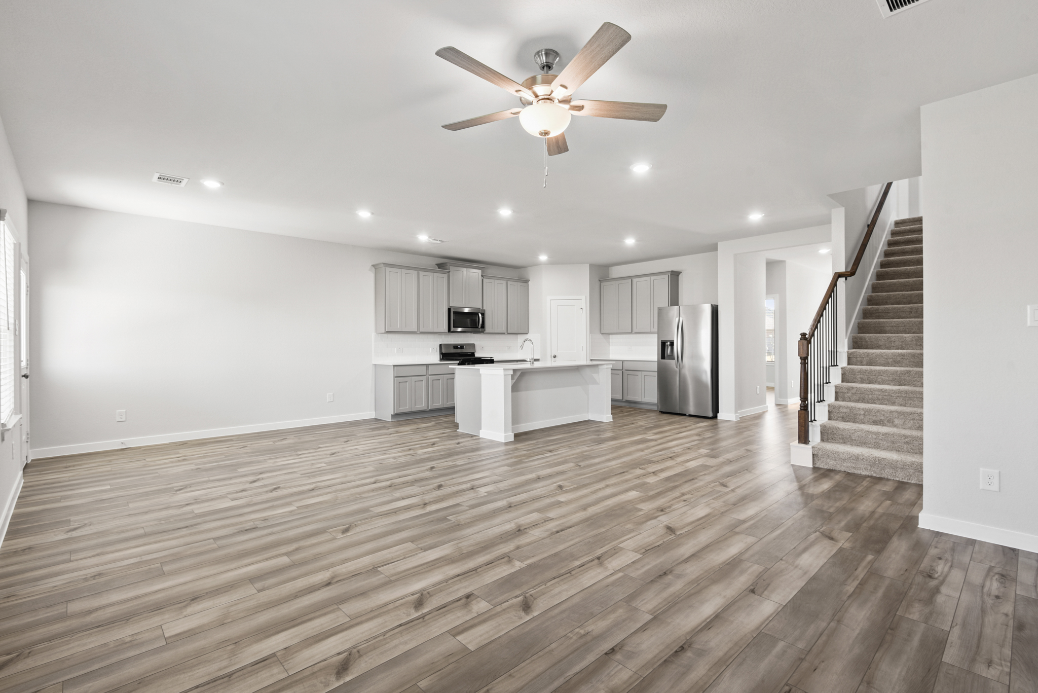 A large kitchen with a wood floor.