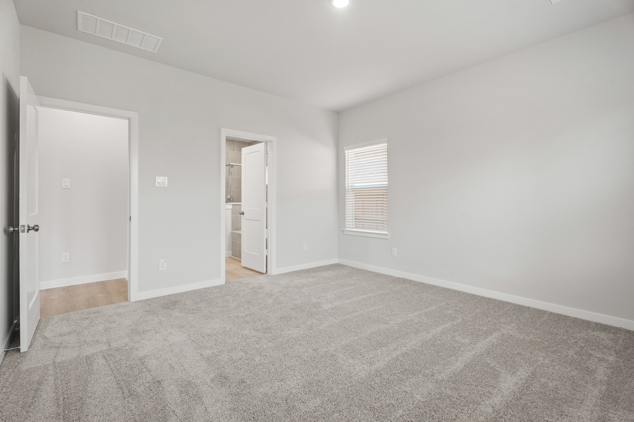 A room with a carpet and a door.