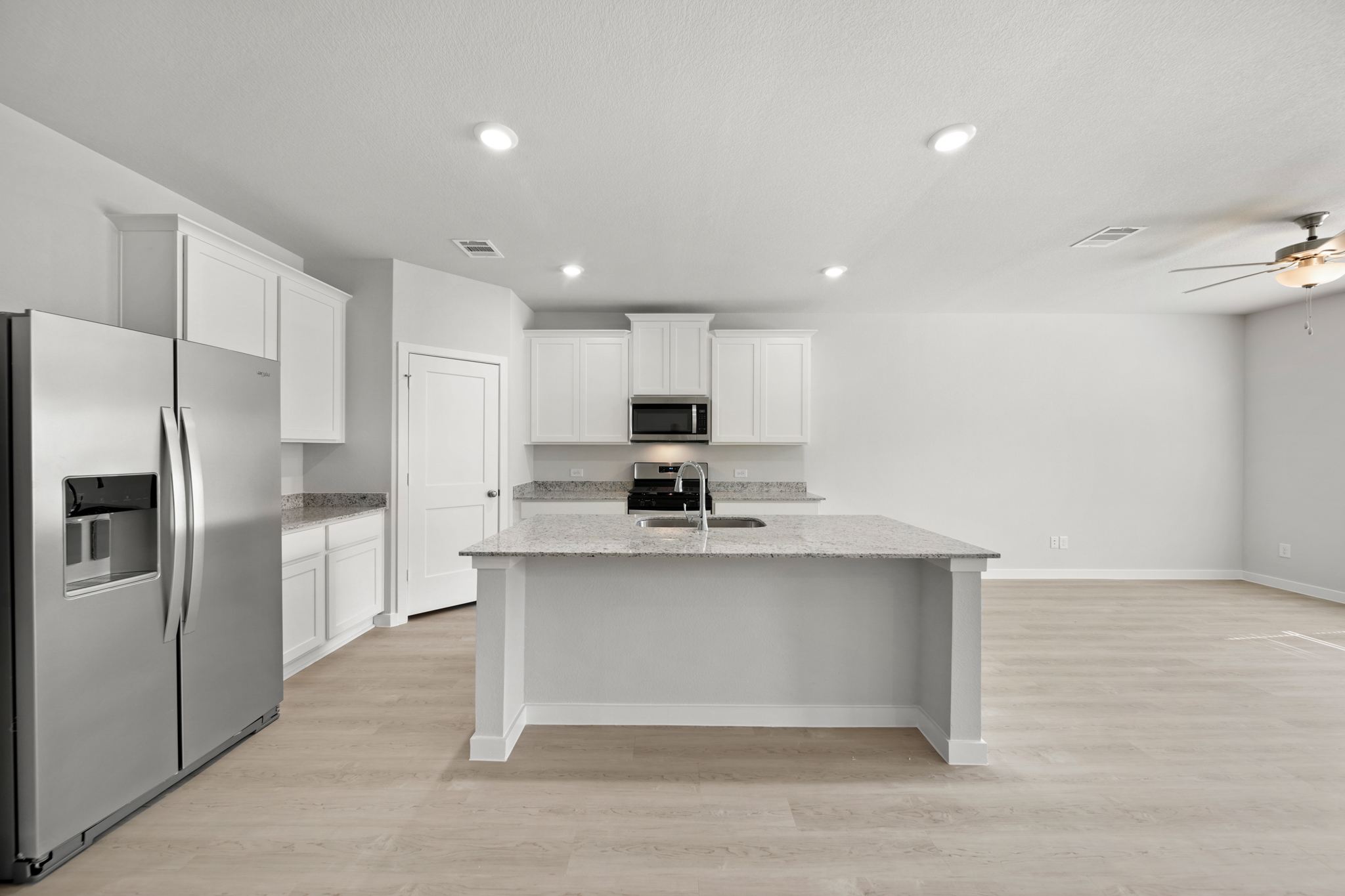 A kitchen with white cabinets.