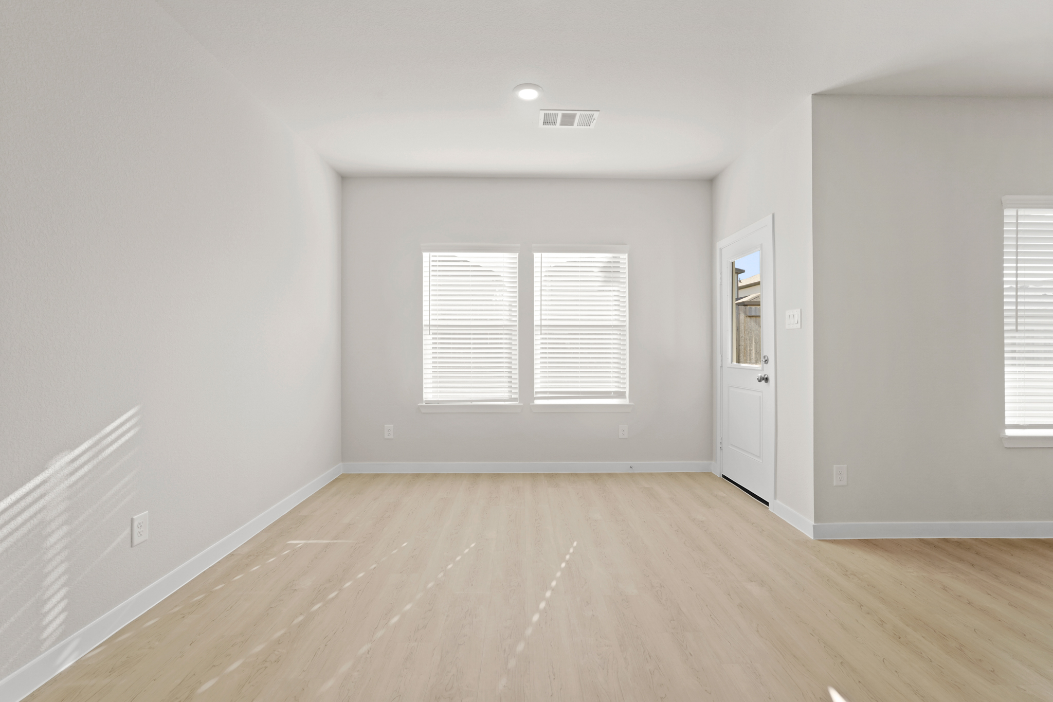 A room with white walls and a wood floor.