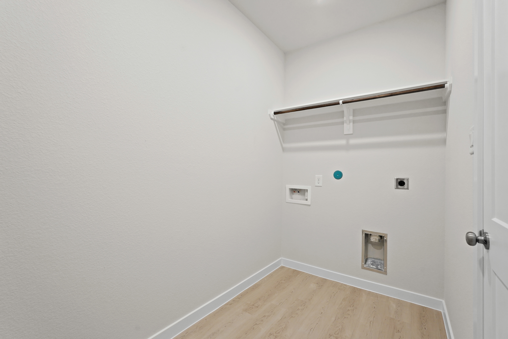 A white room with a wood floor and a white door.