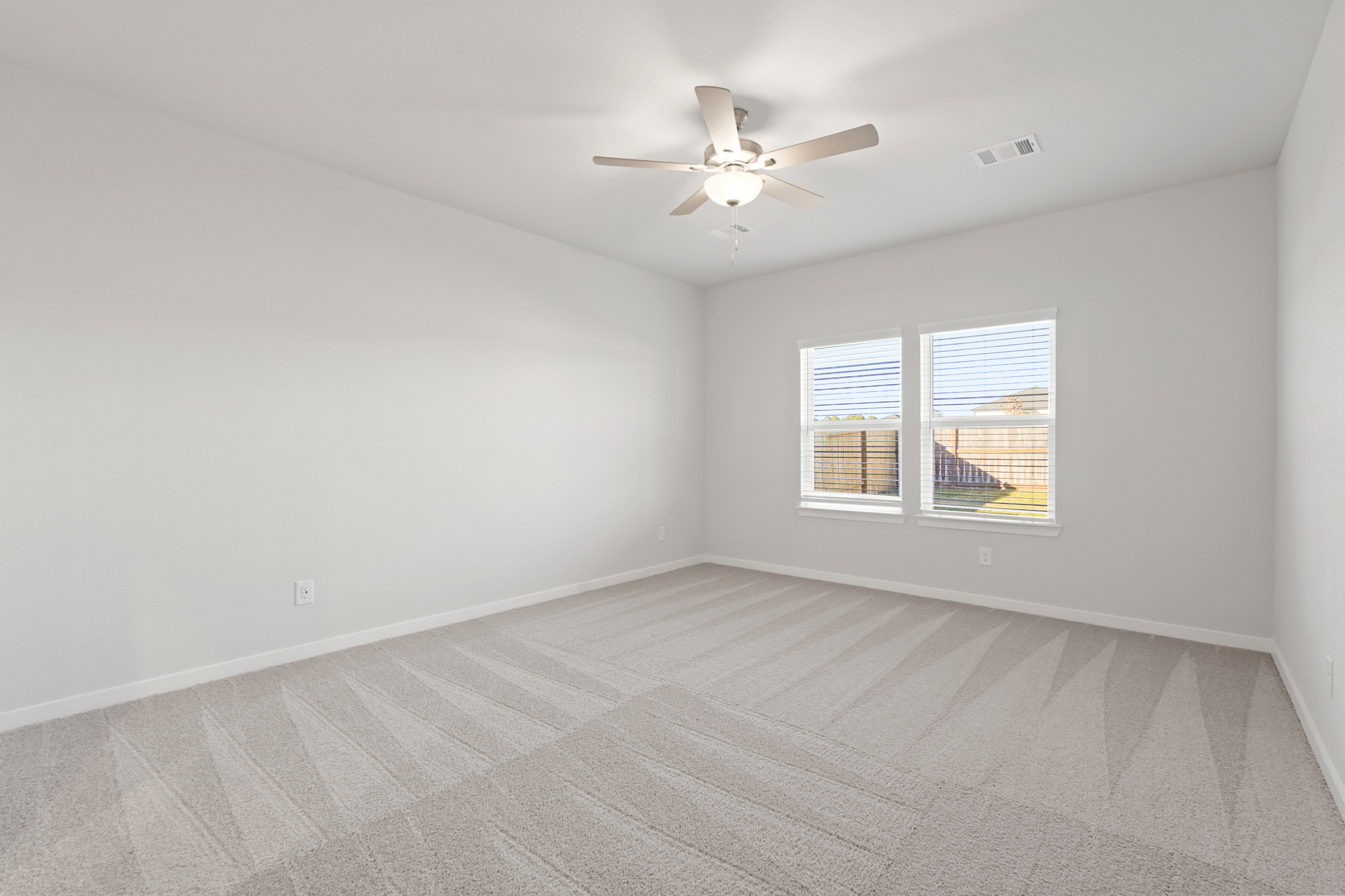A room with a ceiling fan and a window.