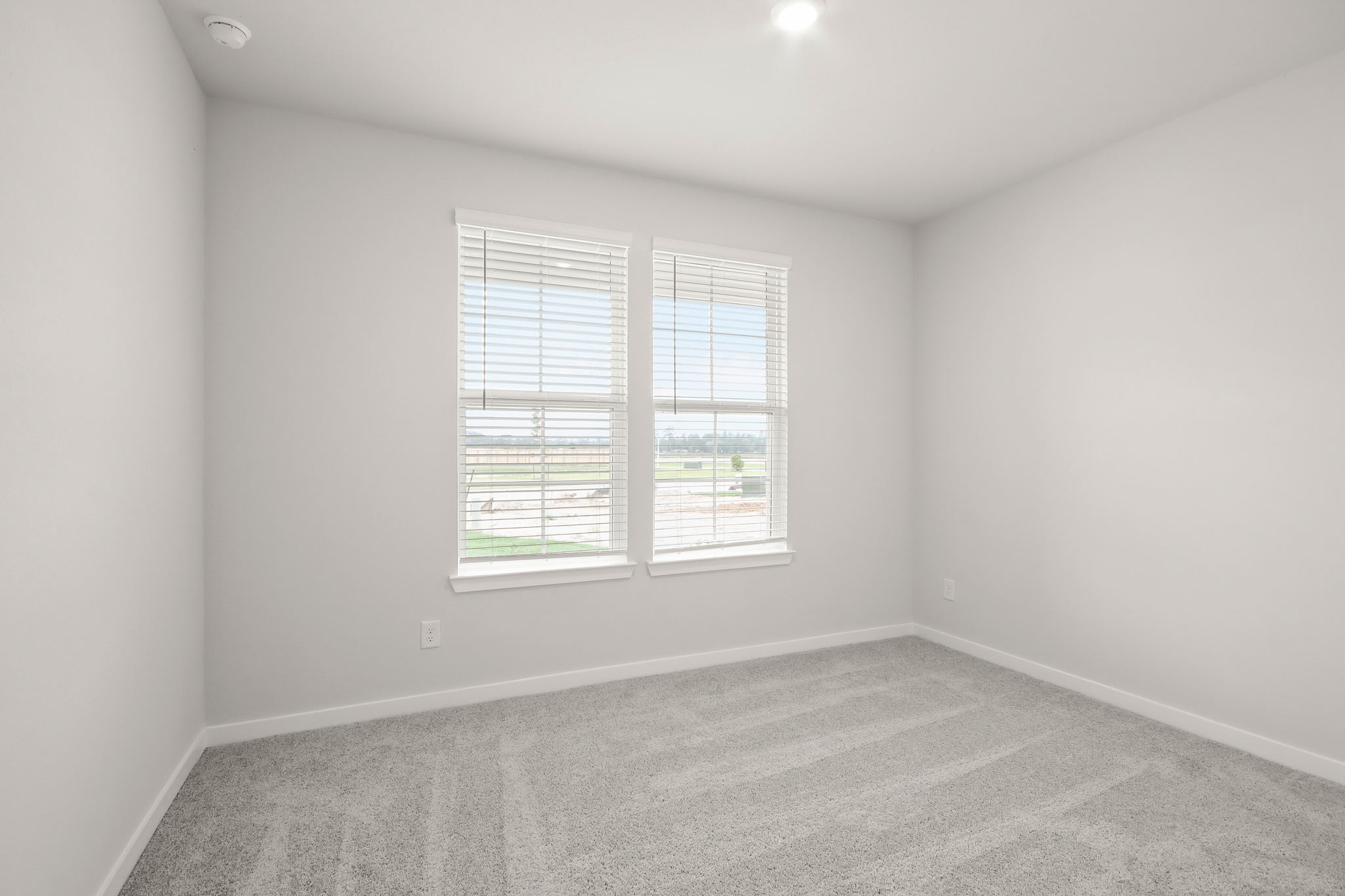 A room with a window and a carpet.