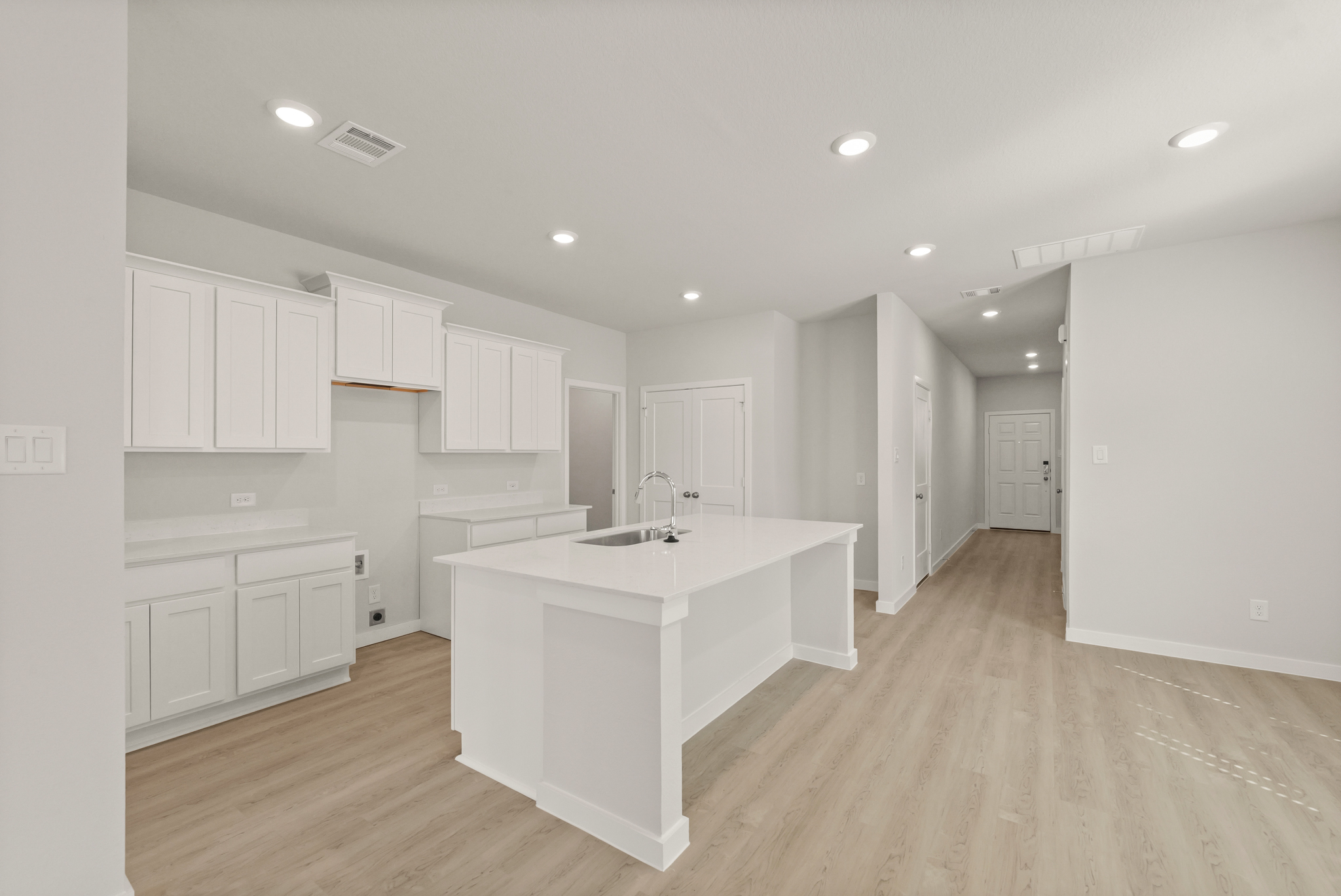 A kitchen with white cabinets.