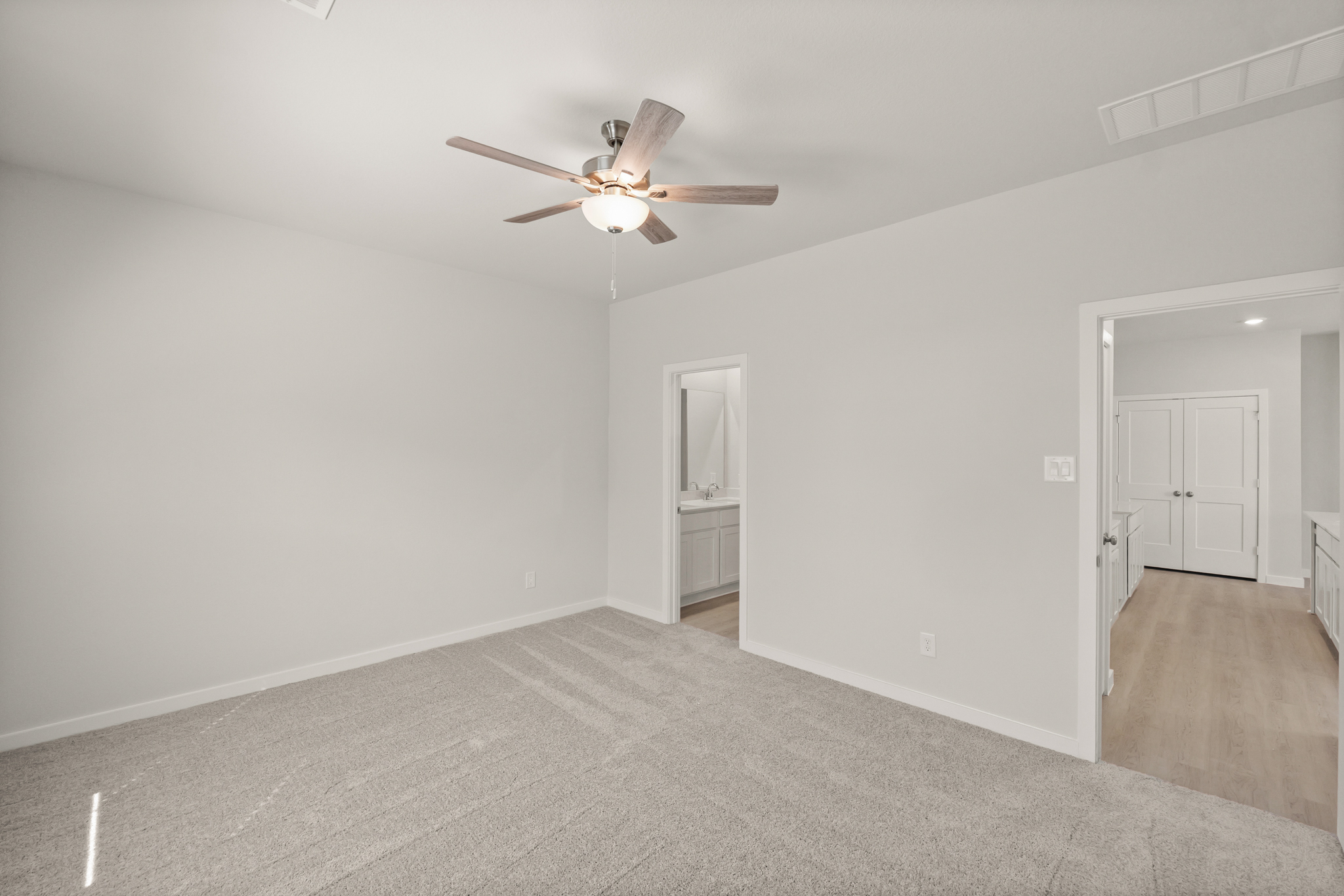 A room with a ceiling fan and a door.