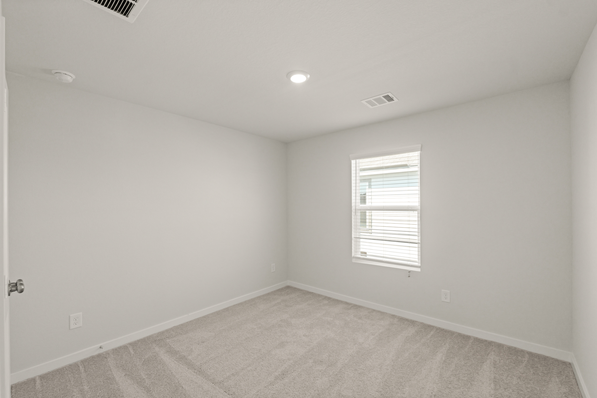 A room with a carpet and a window.