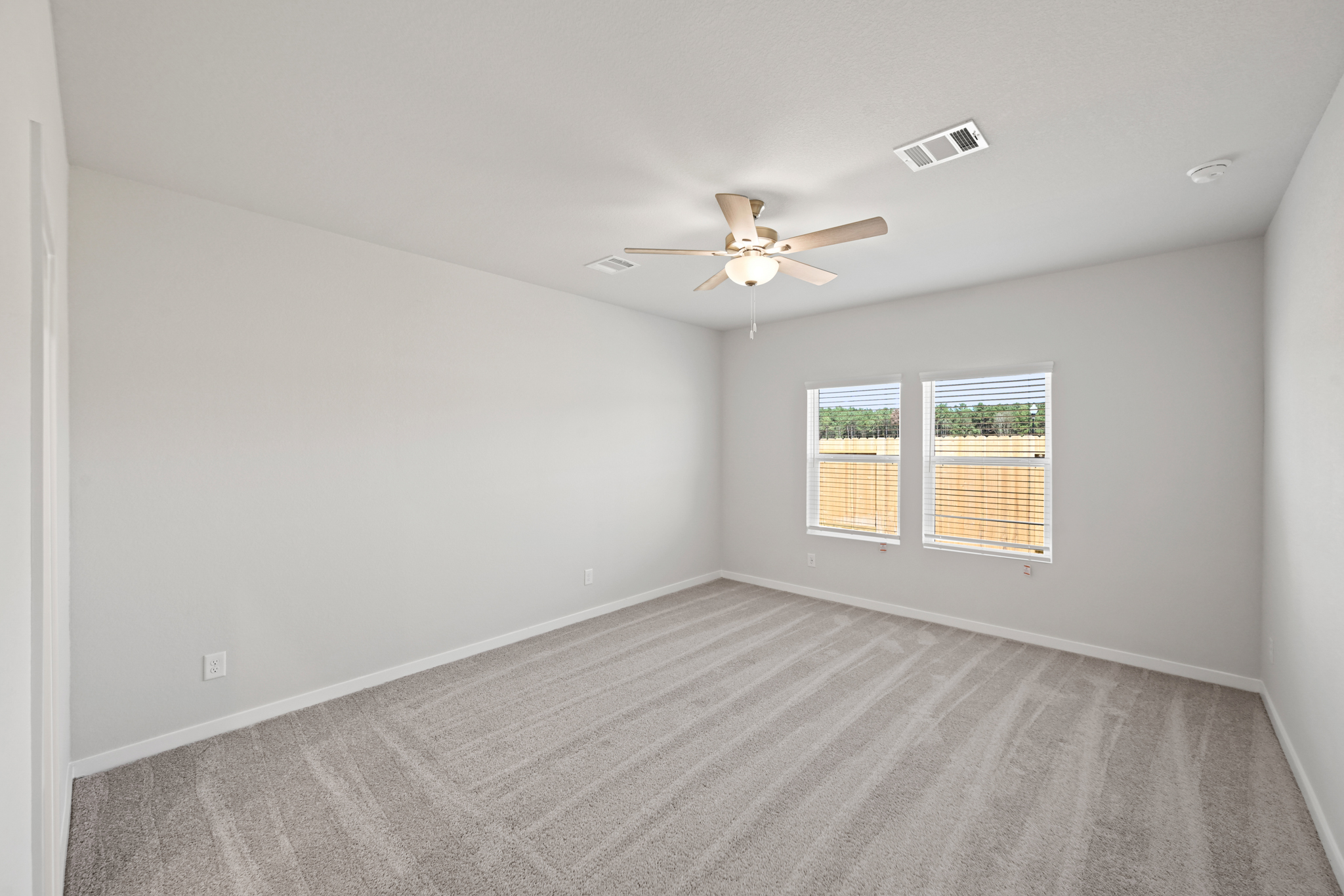 A room with a ceiling fan and a window.