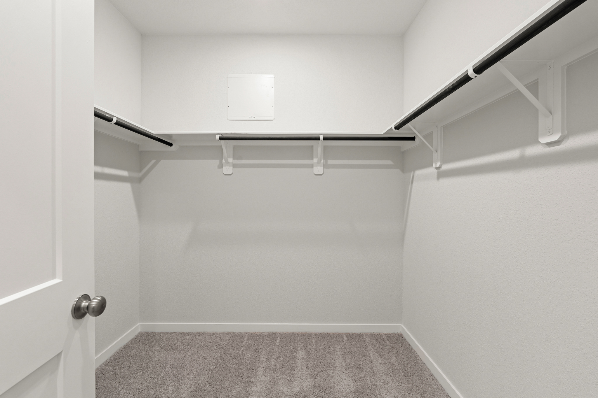 A white room with a grey carpet.