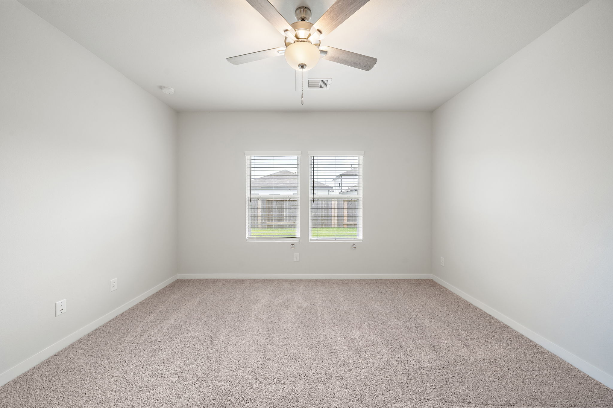 A room with a ceiling fan and a window.