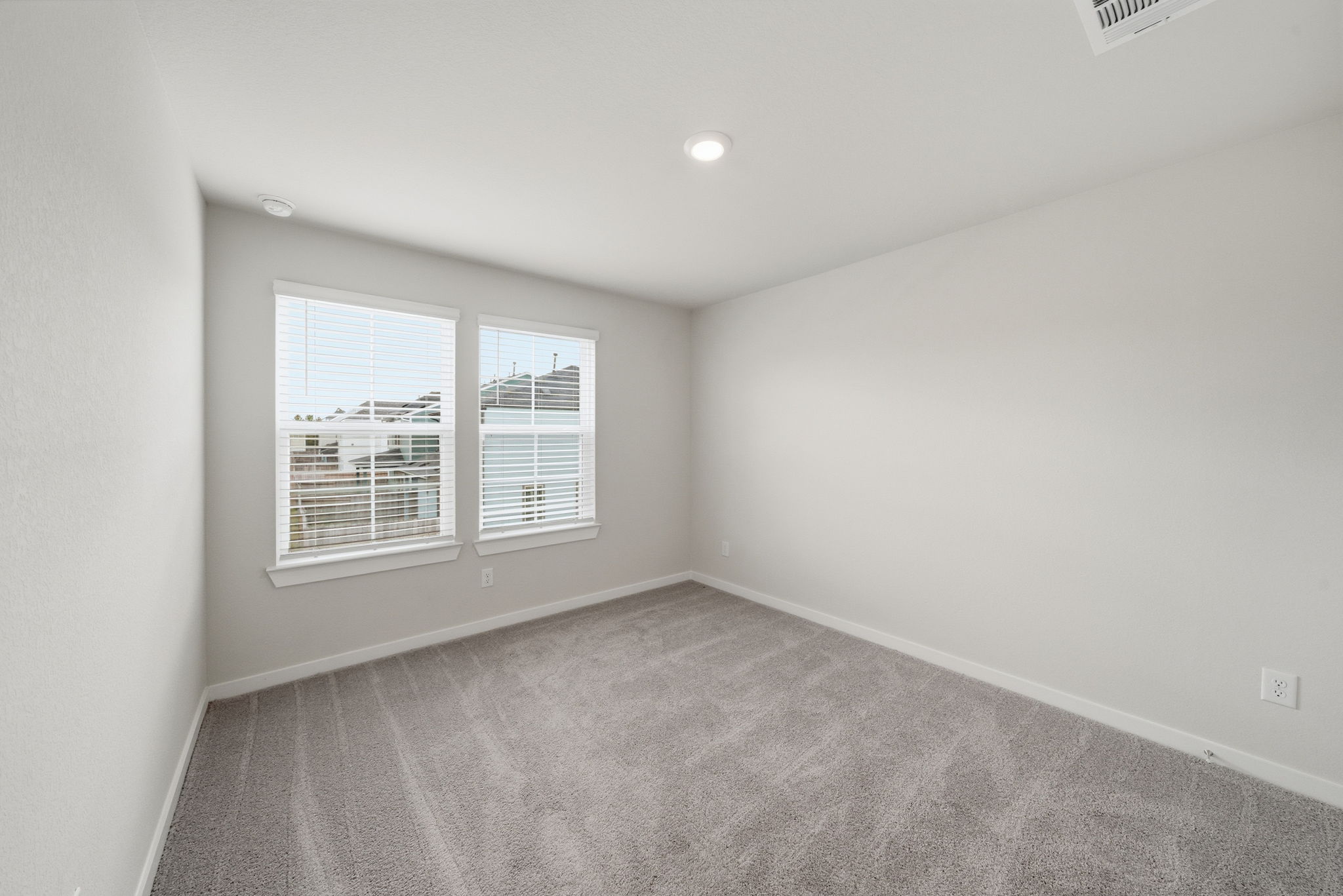 A room with a window and a carpet.