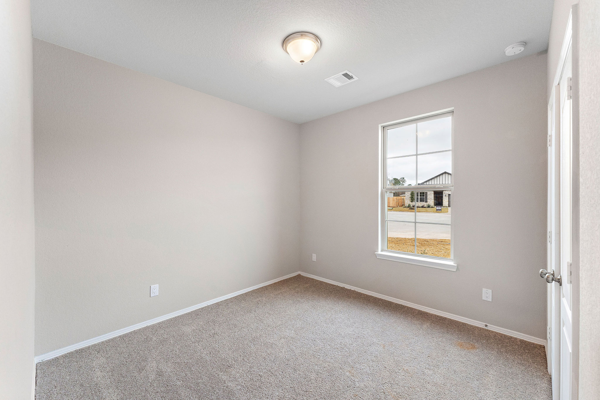 A room with a window and carpet.