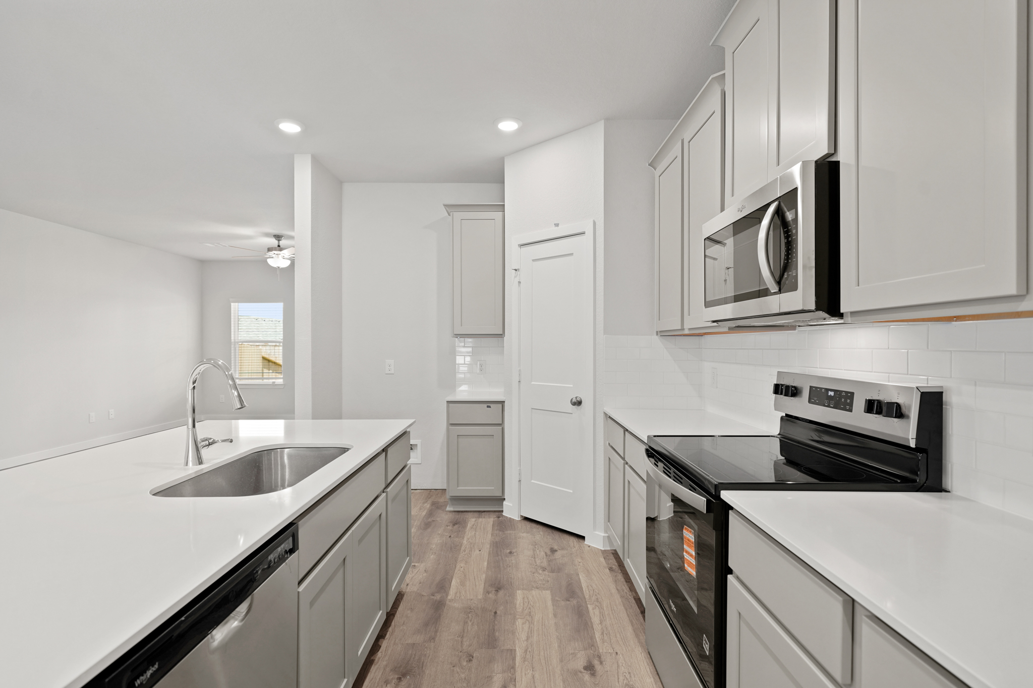 A kitchen with white cabinets.