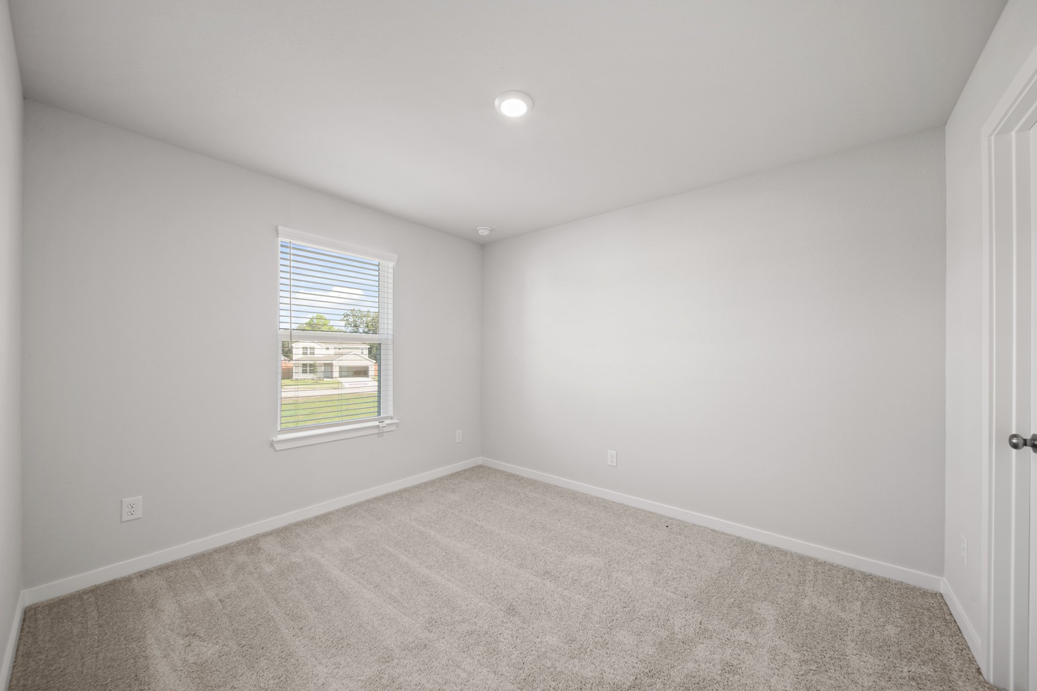 A room with a window and carpet.