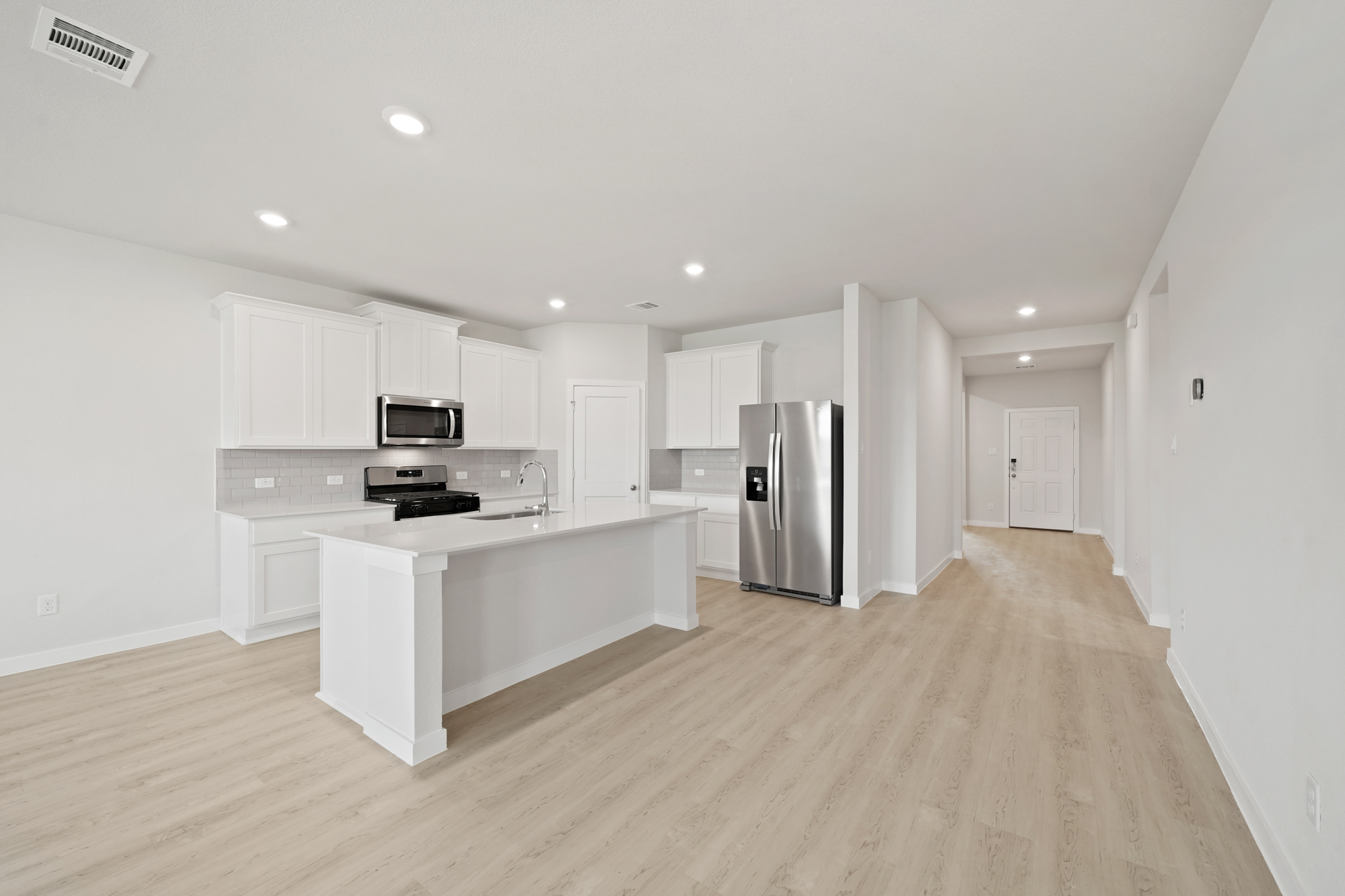 A kitchen with white cabinets.
