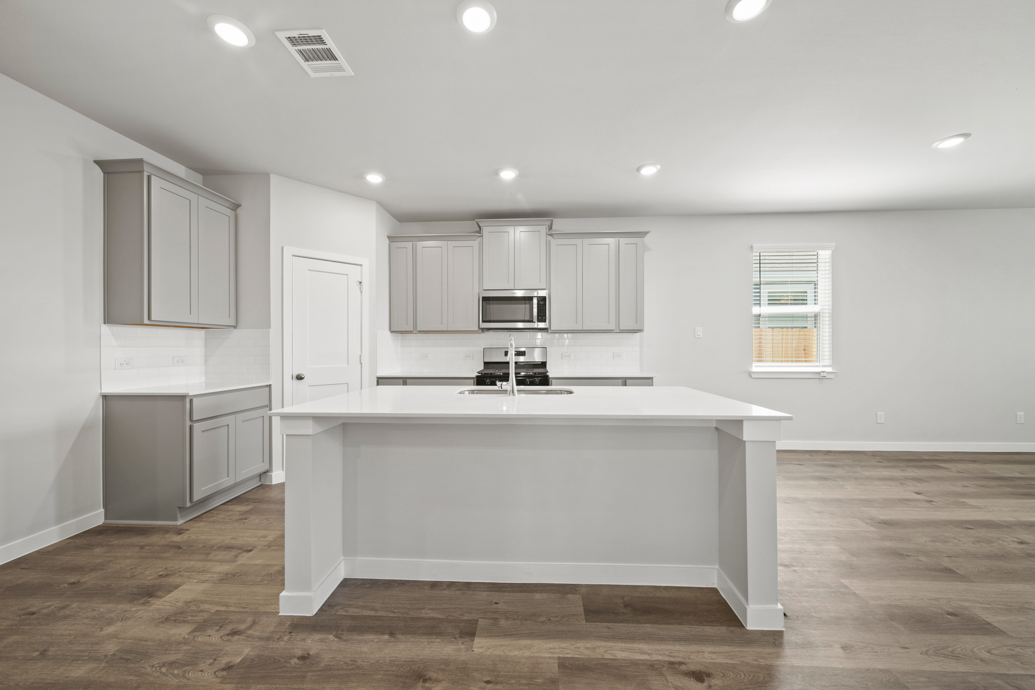 A kitchen with white cabinets.