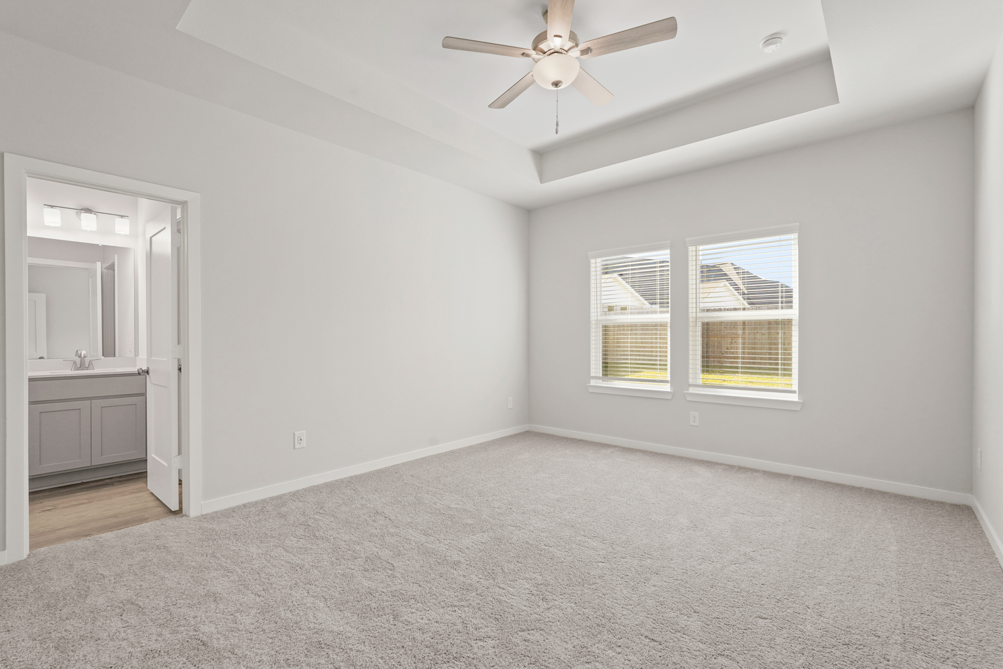 A room with a ceiling fan and a window.