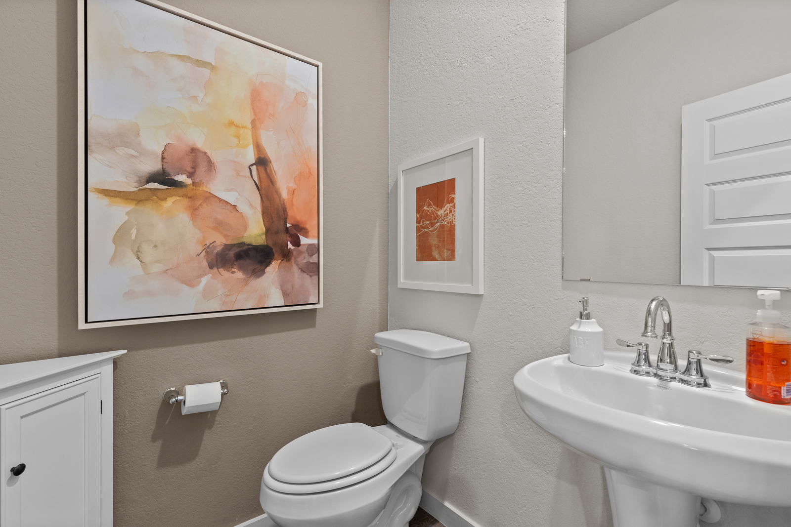 A bathroom with a painting on the wall.