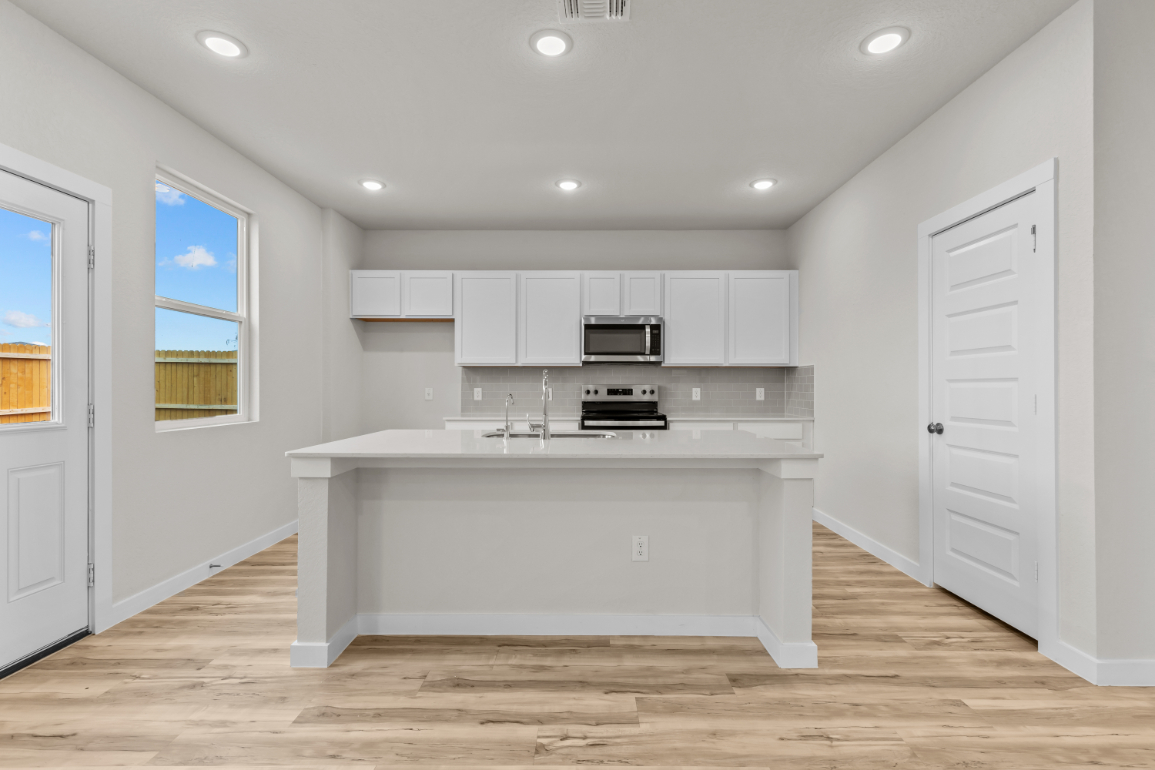 A kitchen with white cabinets.