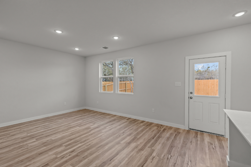 A room with a wood floor and a white door.