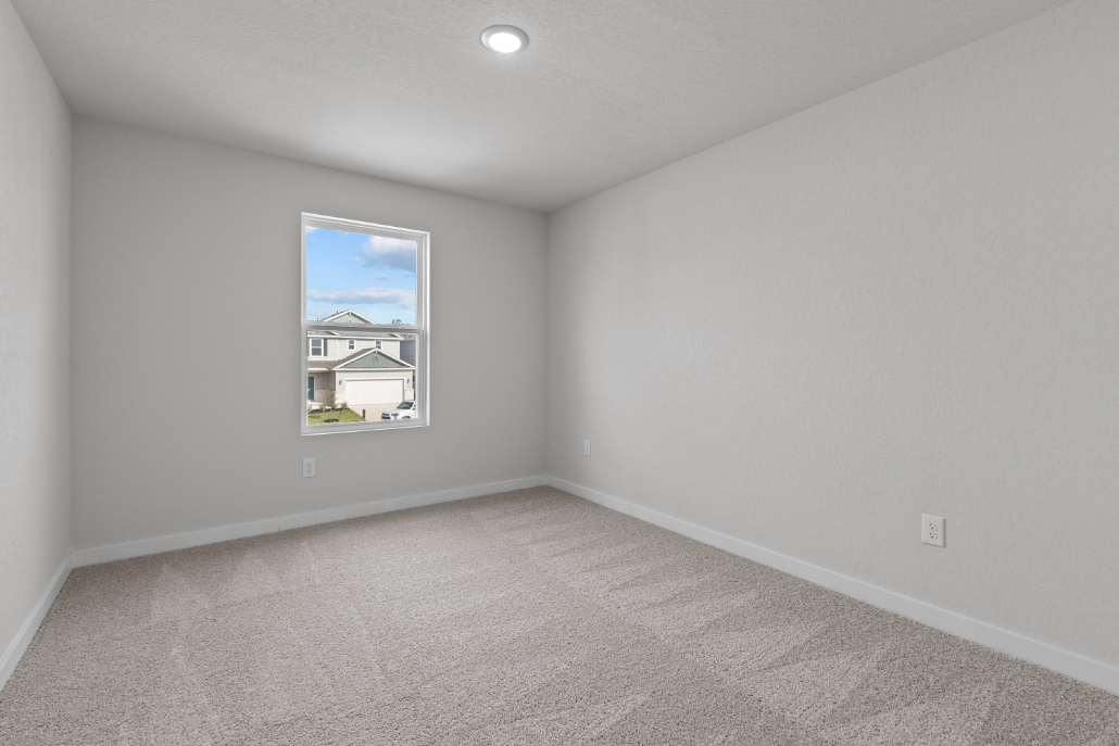 A room with a window and a carpet.