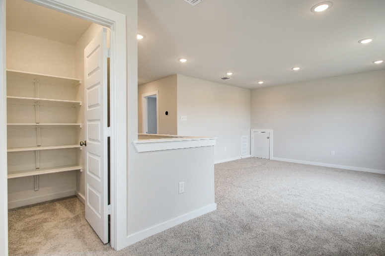 A room with a white shelf and a white cabinet.