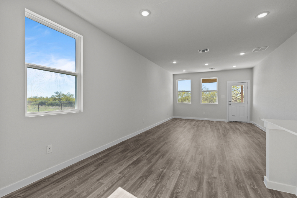 A room with a wood floor and windows.