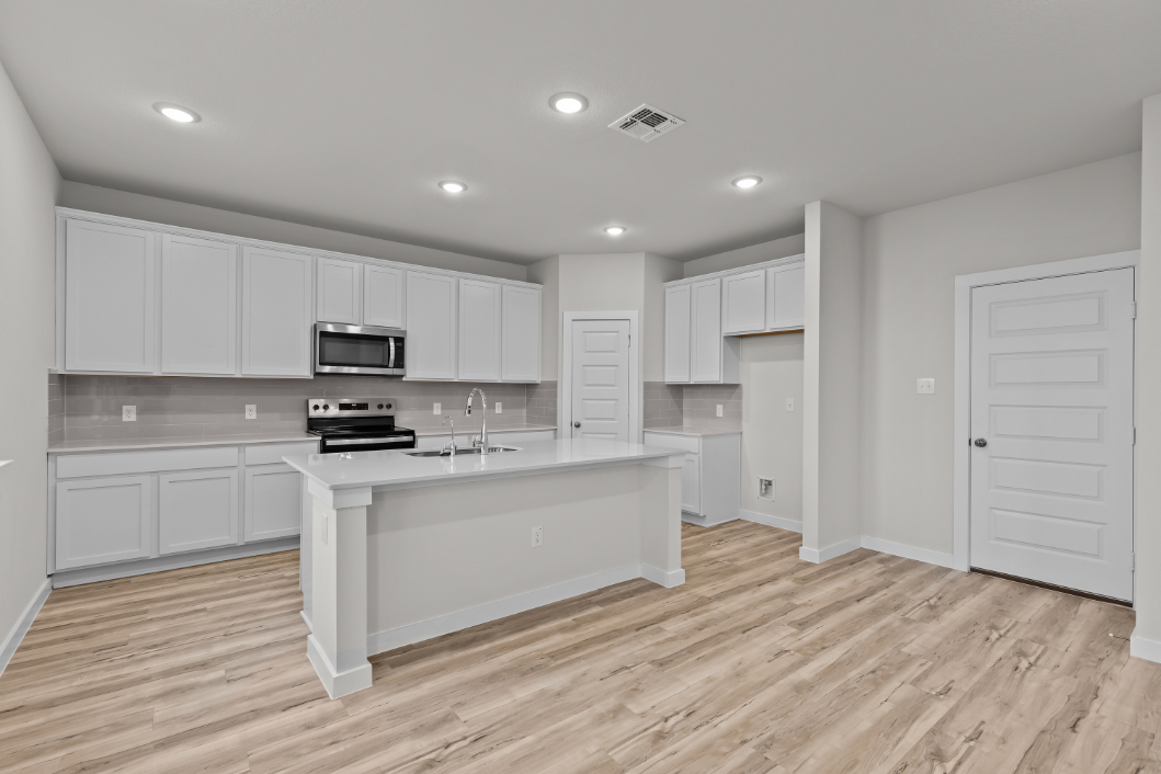 A kitchen with white cabinets.
