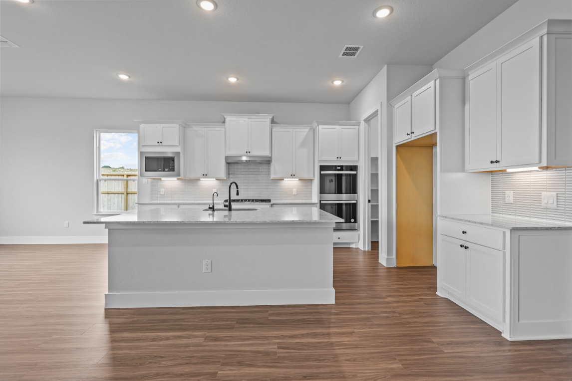A kitchen with white cabinets.