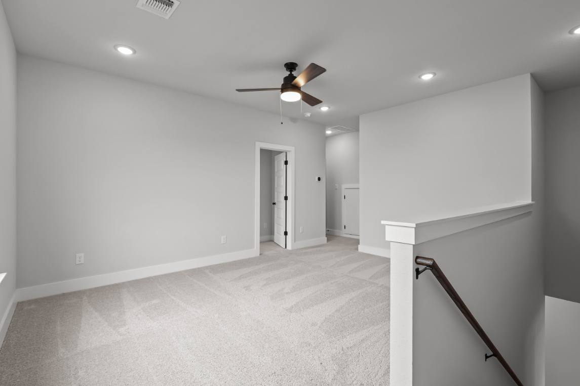 A room with white walls and a ceiling fan.