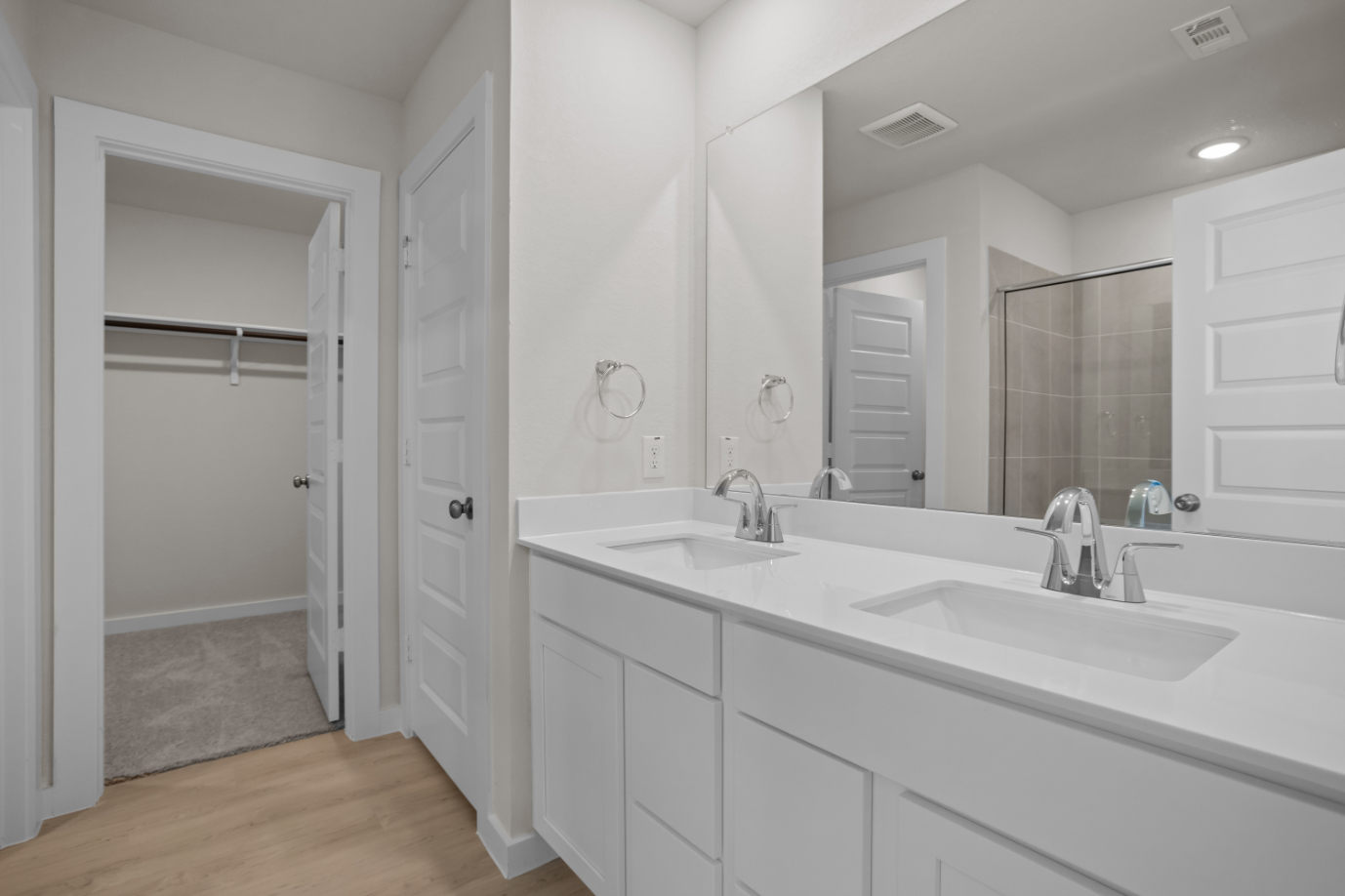 A bathroom with white cabinets.