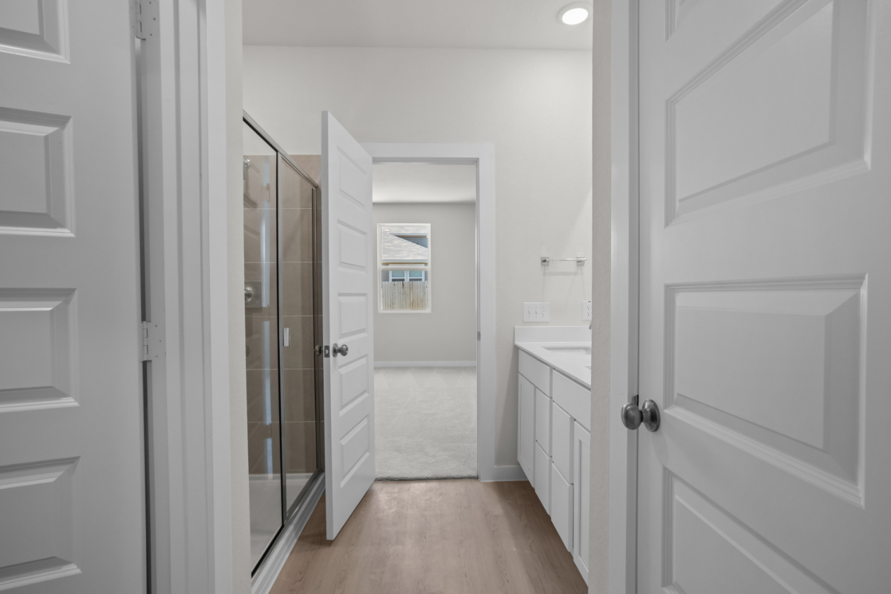 A bathroom with white cabinets.