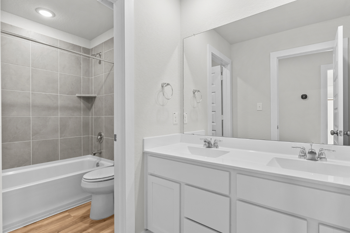 A bathroom with a tub sink and toilet.