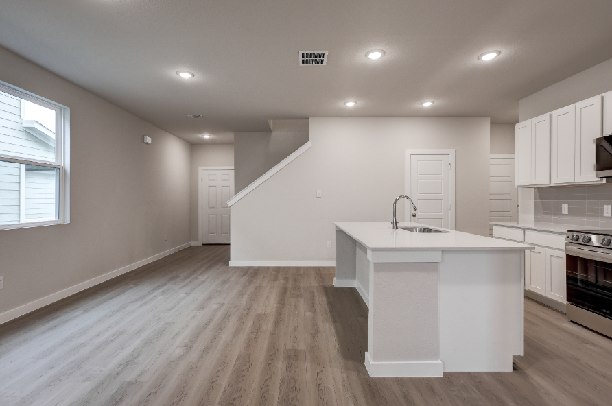 A kitchen with white cabinets.
