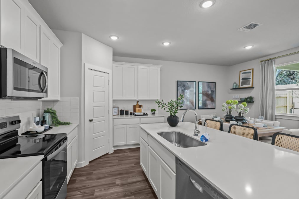 A kitchen with white cabinets.