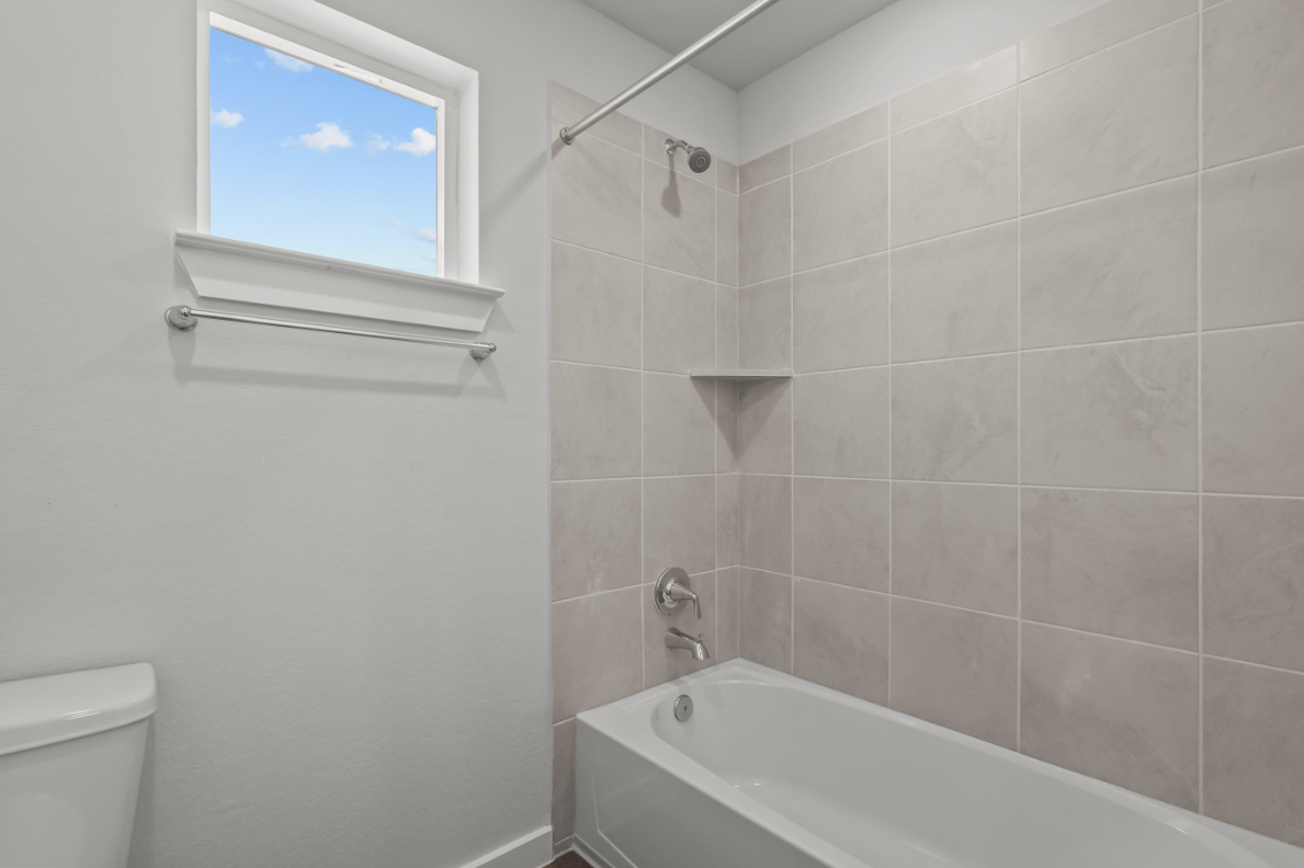 A bathroom with a bathtub and toilet.