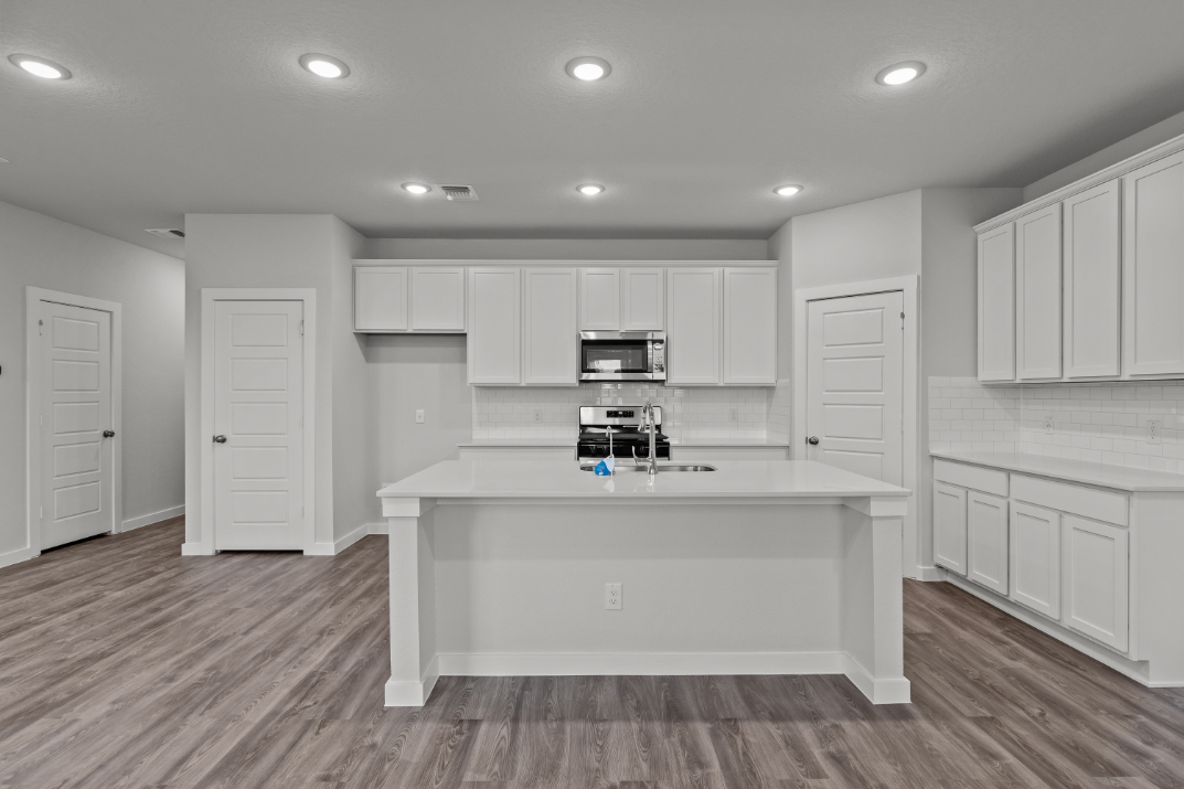A kitchen with white cabinets.