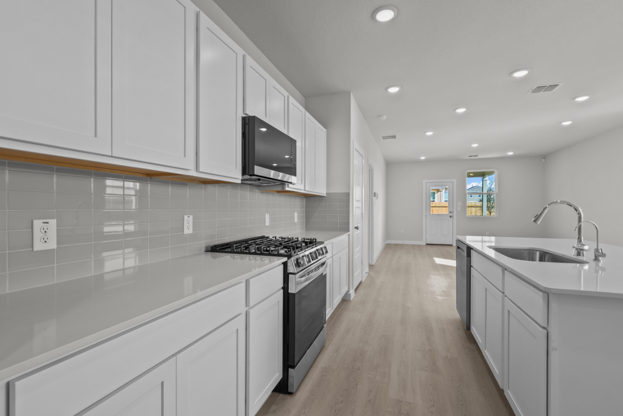 A kitchen with white cabinets.