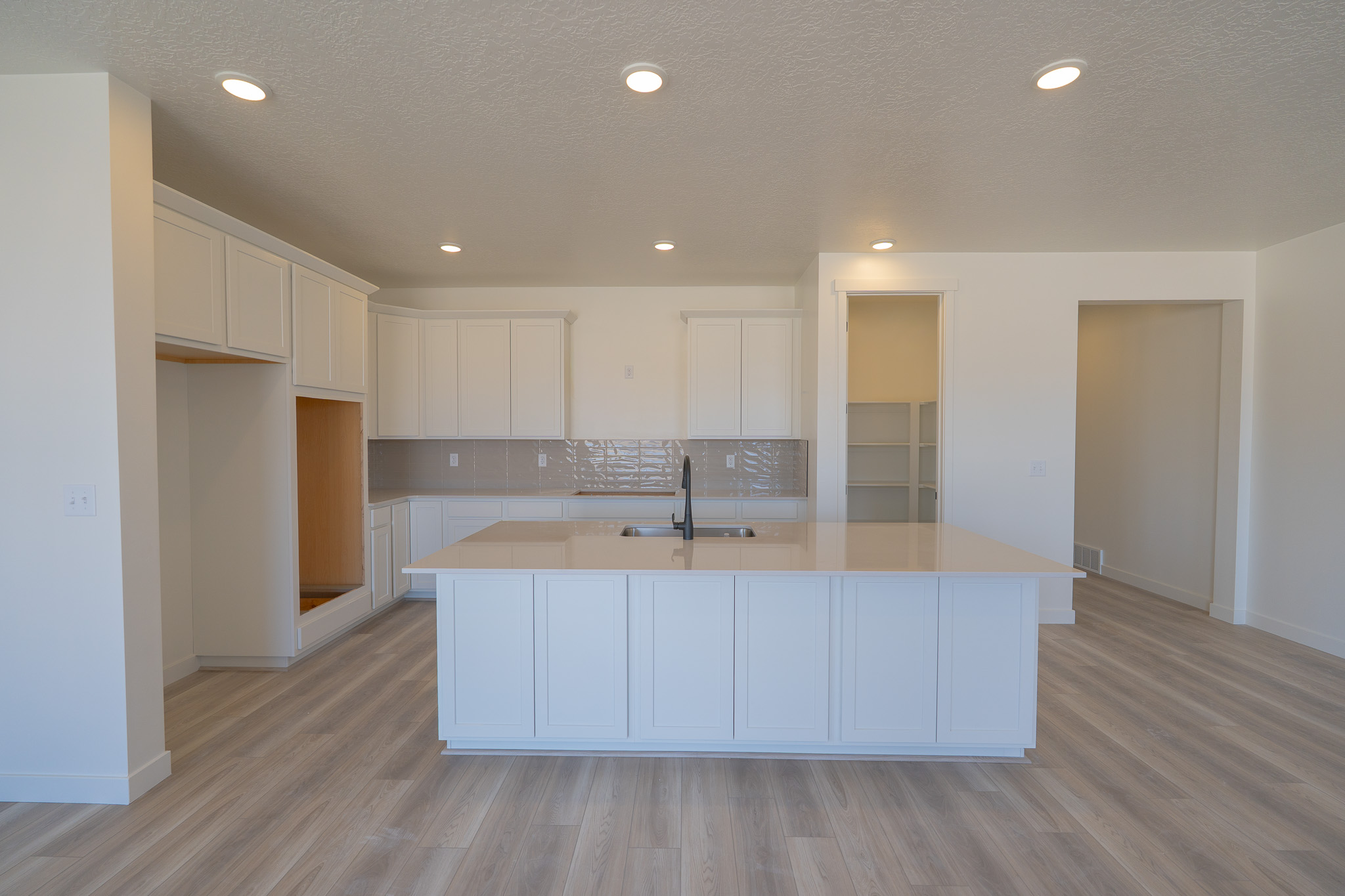 A kitchen with white cabinets.